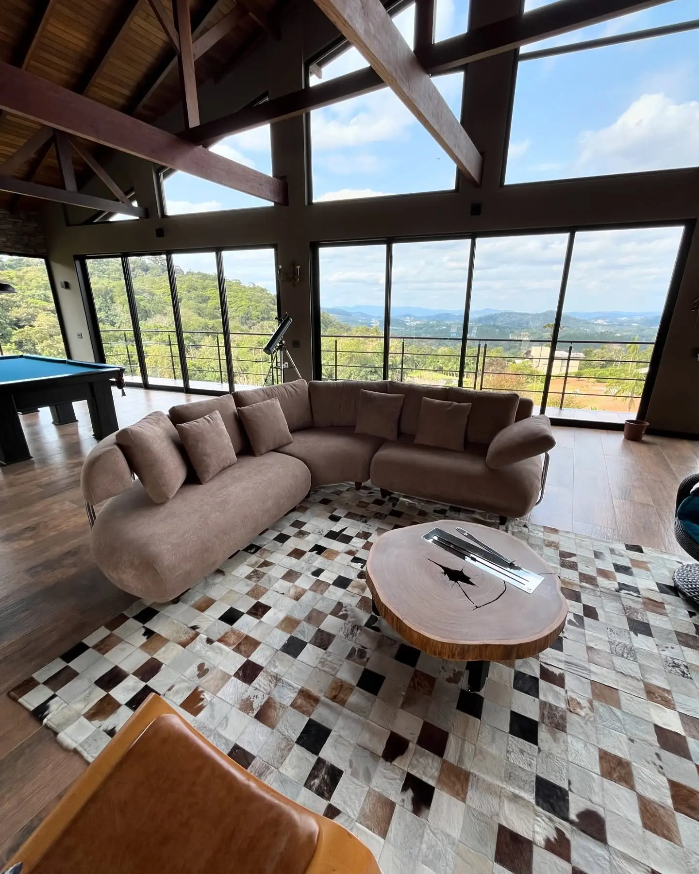 Sofá curvo sob medida em tecido rosé em sala com vista para o vale